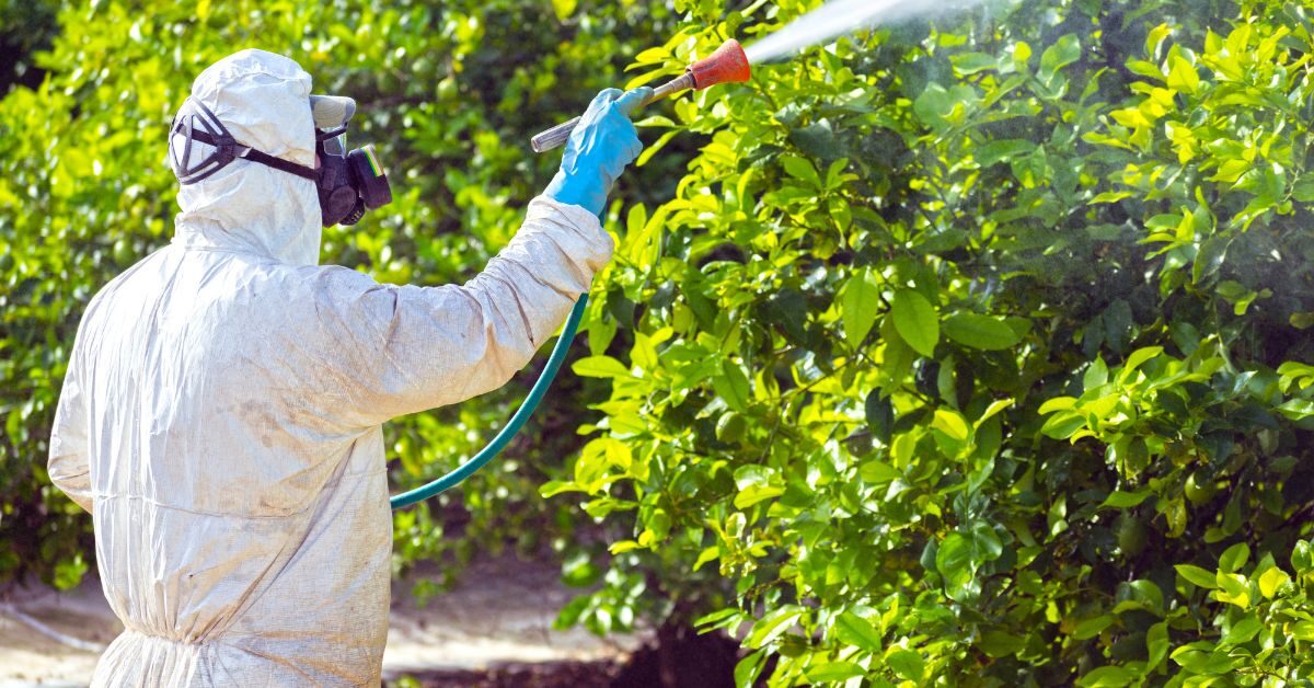 Operative applying targeted weed spray in protective kit